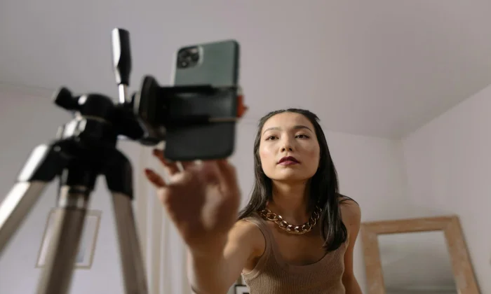 Creator using smartphone to report stolen content on TikTok platform interface